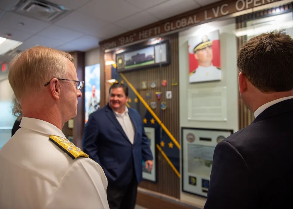 The memorial wall inside the Hefti Global LVC Operations Center, featuring Bag's portrait, command patches, and career memorabilia