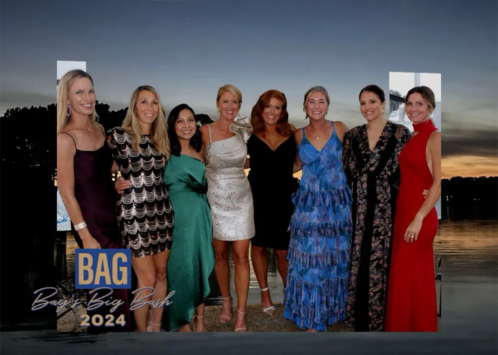 Guests in colorful gowns gathered at sunset on the waterfront